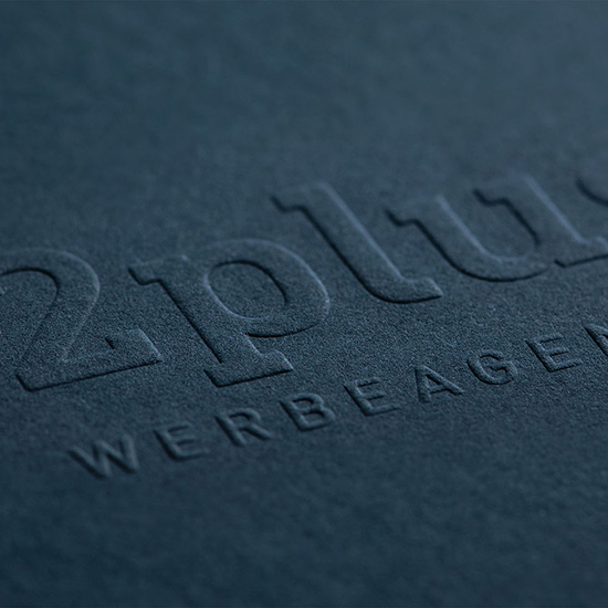 Logo der 2PLUS Werbeagentur als Hochprägung auf Papier.